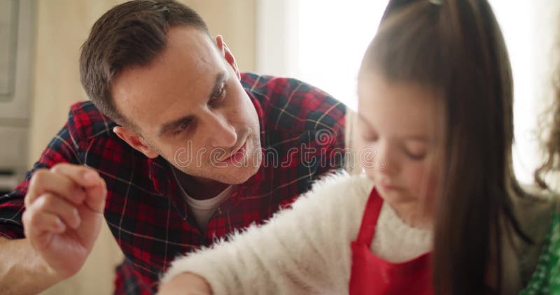 Papa und seine kleine Tochter schmücken Kekse