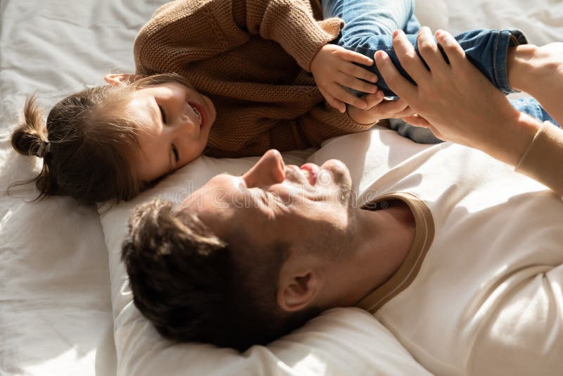 Papa Verbringe Zeit mit weniger Tochter, die zusammen im Bett ist stockbilder