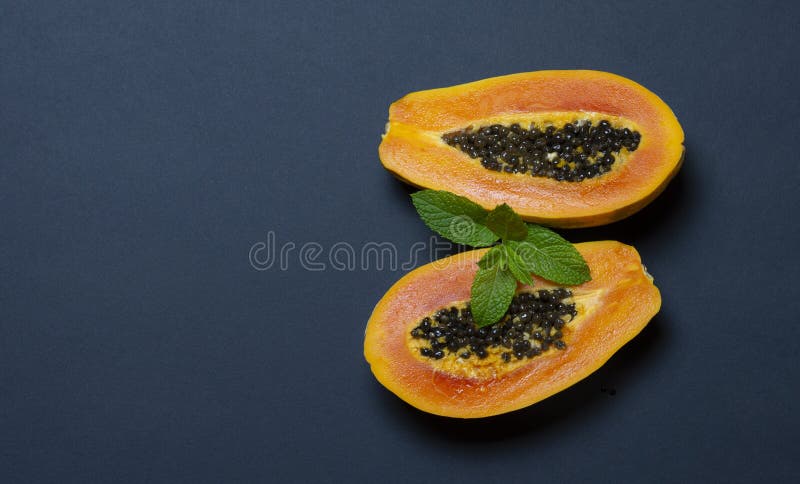 Papaya en fondo oscuro azulado con el espacio para su texto - imagen imagen de archivo Papaya en fondo oscuro azulado con el espacio para su texto - imagen imagen de archivo