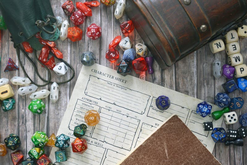 Papel de tabletop jugando en el suelo con coloridos RPG y juegos, hoja de caracteres, libro de reglas y cofre del tesoro foto de archivo