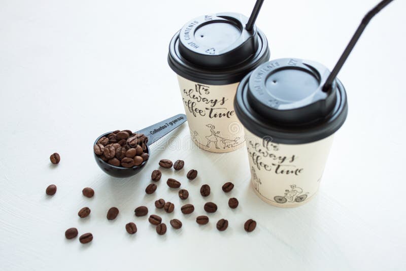 Paper coffee cup from coffee shop with coffee beans near the window. Lifestyle concept