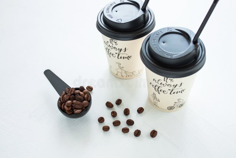 Paper coffee cup from coffee shop with coffee beans near the window. Lifestyle concept