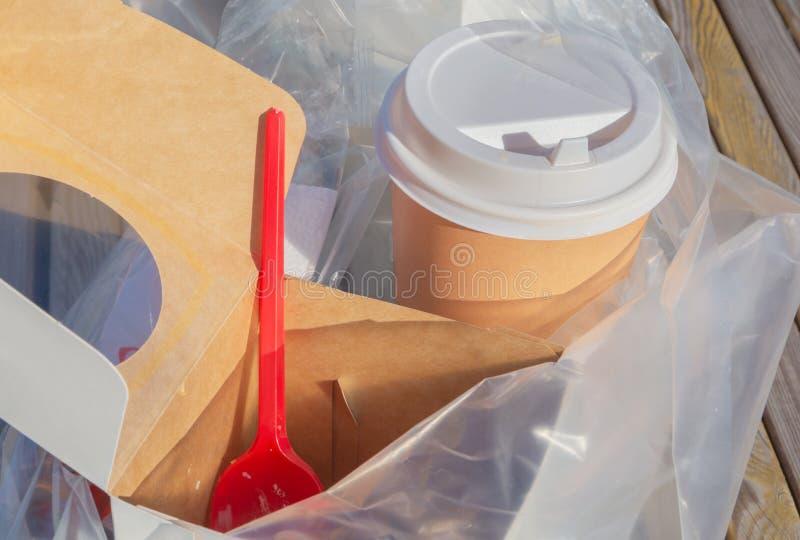 Paper cups for coffee, and packaging for food, plastic lids are assembled in one plastic bag stock photography