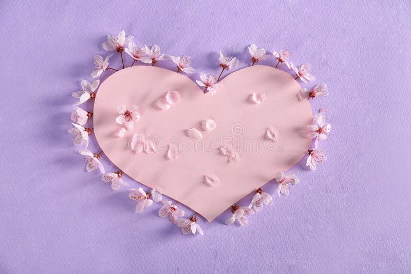Paper heart and blossoming spring flowers on color background stock photo Paper heart and blossoming spring flowers on color background stock photo