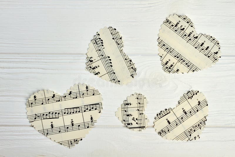 Paper hearts with musical notes. Set of paper hearts with musical notes on light wooden background.