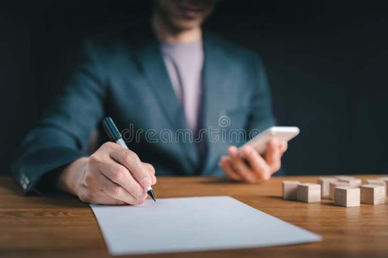 On paper, the man's hand is signed, and on the virtual screen, the home sign appears. Taxation, savings, budgeting, interest stock photography