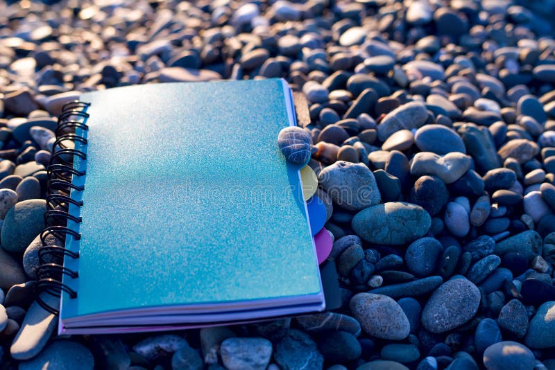 Paper notebook lying at on sea beach.