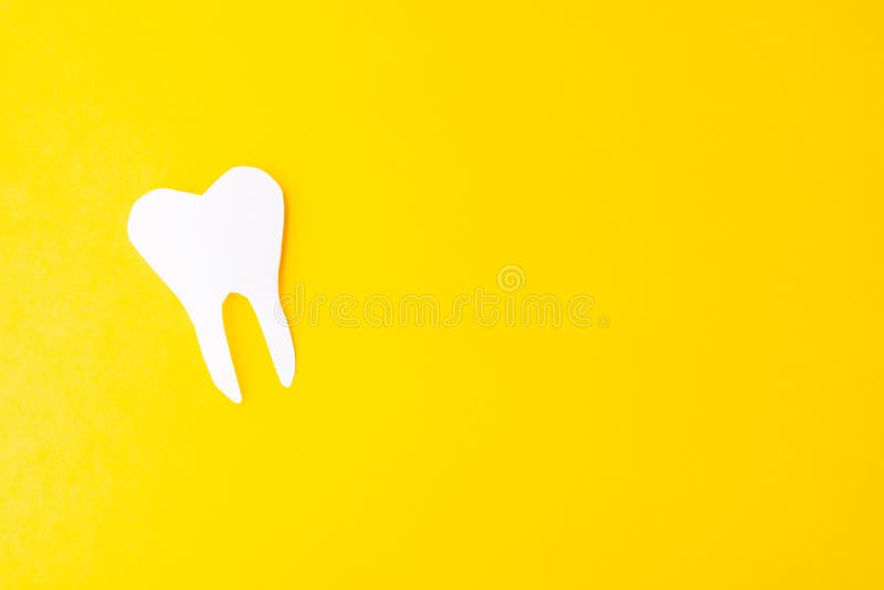 Paper tooth on a yellow background. Place for text, brush, care, clean, dental, health, healthy, hygiene, medical, medicine, object, space, toothbrush, concept, copy, dentist, dentistry, mouth, oral, white, abstract, card, clinic, day, design, doctor, emblem, enamel, flat, greeting, happy, holiday, hospital, international, isolated, lay, march, molar, professional, root, shape, symbol, toothache, whitening, world. Paper tooth on a yellow background. Place for text, brush, care, clean, dental, health, healthy, hygiene, medical, medicine, object, space, toothbrush, concept, copy, dentist, dentistry, mouth, oral, white, abstract, card, clinic, day, design, doctor, emblem, enamel, flat, greeting, happy, holiday, hospital, international, isolated, lay, march, molar, professional, root, shape, symbol, toothache, whitening, world