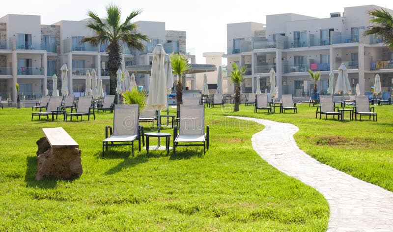 Palm beach with empty sunbeds against Amphora Hotel & Suitel. Set on the idyllic beachfront locati