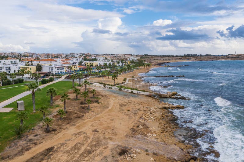 Paphos embankment or promenade, Cyprus, with sandy beach, green palm trees and lawns and small houses on first coastline. Aerial view from drone royalty free stock images Paphos embankment or promenade, Cyprus, with sandy beach, green palm trees and lawns and small houses on first coastline. Aerial view from drone royalty free stock images