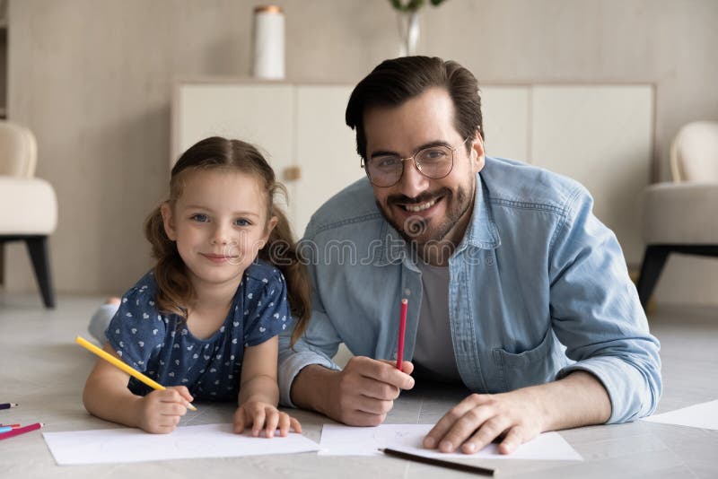 Papi feliz e hijito descansando en el suelo de calefacción fotos de archivo