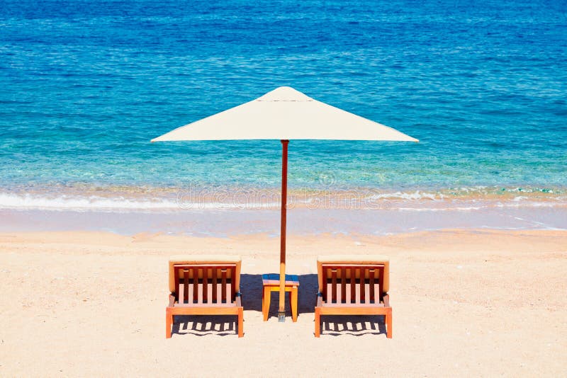 Papier peint de fond de vacances d'été : deux chaises longues de plage sous la tente sur la plage images libres de droits Papier peint de fond de vacances d'été : deux chaises longues de plage sous la tente sur la plage images libres de droits