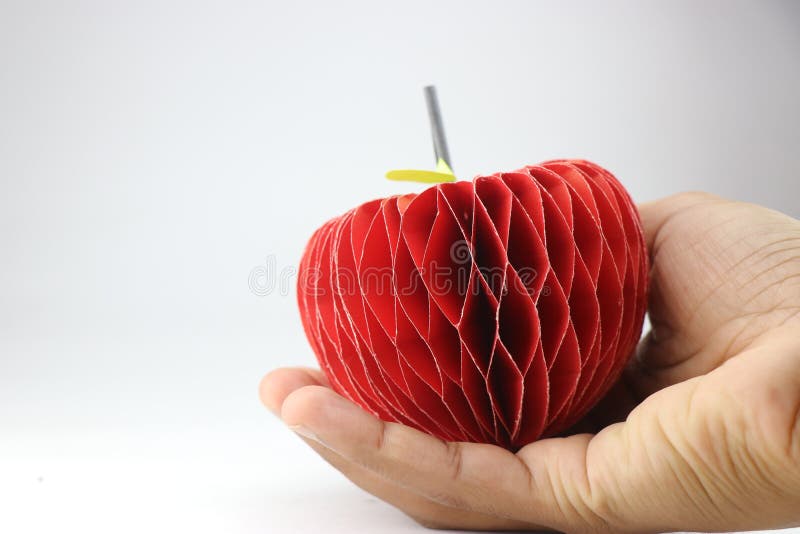 Papierowe jabłko z efektem 3d zrobione z papieru kolorowego trzymanego w ręku z miejscem na tekst kopii. Papierowe jabłko z efektem 3d zrobione z papieru kolorowego trzymanego w dłoni i spacją na tekst kopii