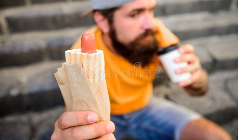 Papierowej filiżanki kawa i hot dog uliczna karmowa tradycyjna przekąska Mężczyzna modniś szybkiego lunch siedzieć schodka tło Lu zdjęcie stock Papierowej filiżanki kawa i hot dog uliczna karmowa tradycyjna przekąska Mężczyzna modniś szybkiego lunch siedzieć schodka tło Lu zdjęcie stock