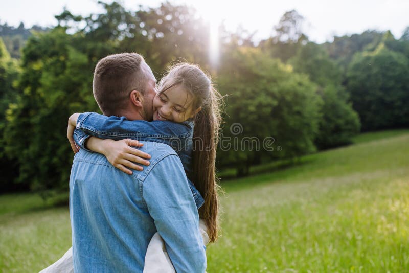 Pappa med dotters huggande på ängslöpning med kul. Fader Day och faderlig kärlek. royaltyfri fotografi