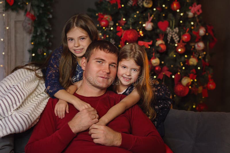 Pappa med två döttrar firar jul royaltyfria bilder