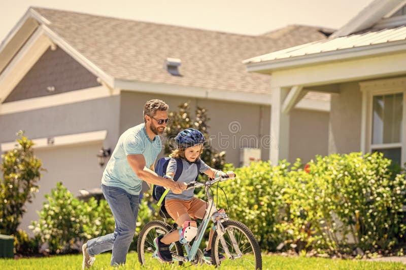Pappa och son duo som pedalerar genom bildlandskap. Understödjande pappa som vägleder sin son första cykeltur. pappa och son royaltyfri foto