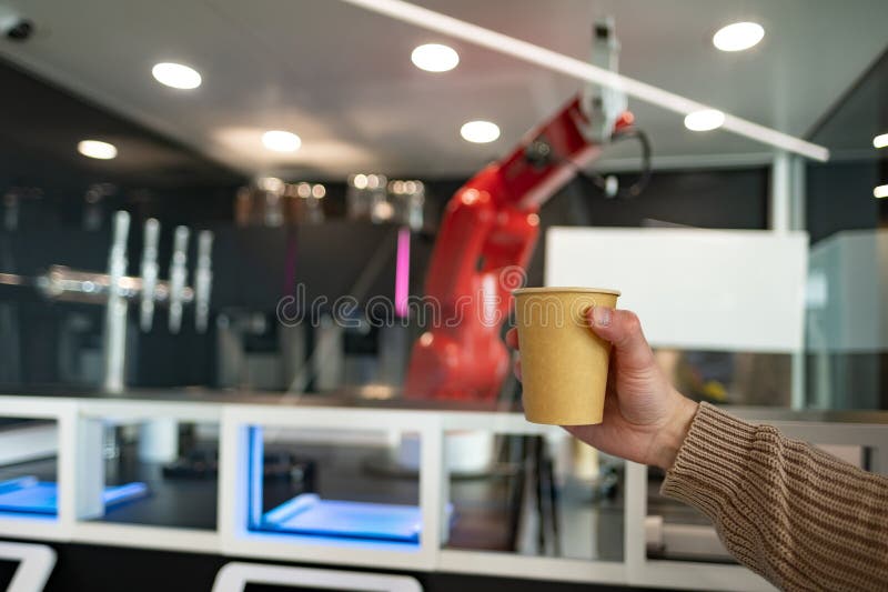 Papperskopp i handrött robot bereder kaffecharmerande bågduschmöjligheter och precision på ett skickligt sätt arkivbilder