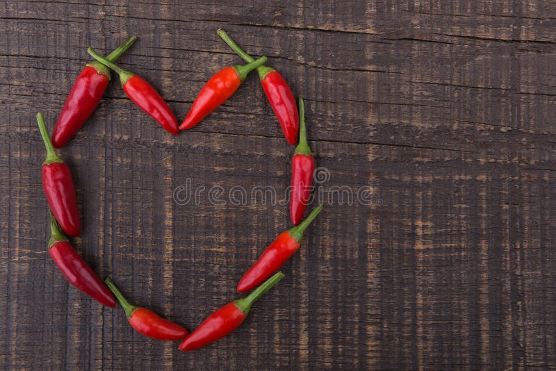 Paprika red pepper in the shape of heart. The texture on a wooden background. Valentine s Day.