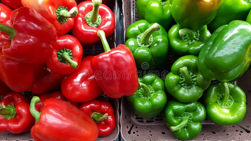Paprikas rouges dans un panier crème et paprikas verts dans un panier crème placé sur le supermarché photographie stock libre de droits Paprikas rouges dans un panier crème et paprikas verts dans un panier crème placé sur le supermarché photographie stock libre de droits