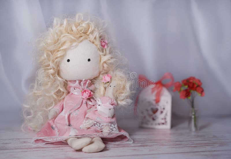 Papusa facuta manual pe o masa alba din lemn cu flori de hartie si cutie pentru cadouri royalty free stock photos