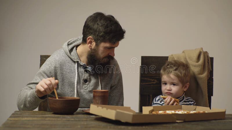 Papà e bambino mangiano pizza. pizzeria. cucina italiana. infanzia felice. pranzo fast-jumping.