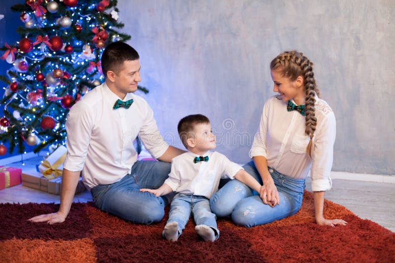 Papá de la mamá y regalos abiertos de una Navidad del niño pequeño por el Año Nuevo