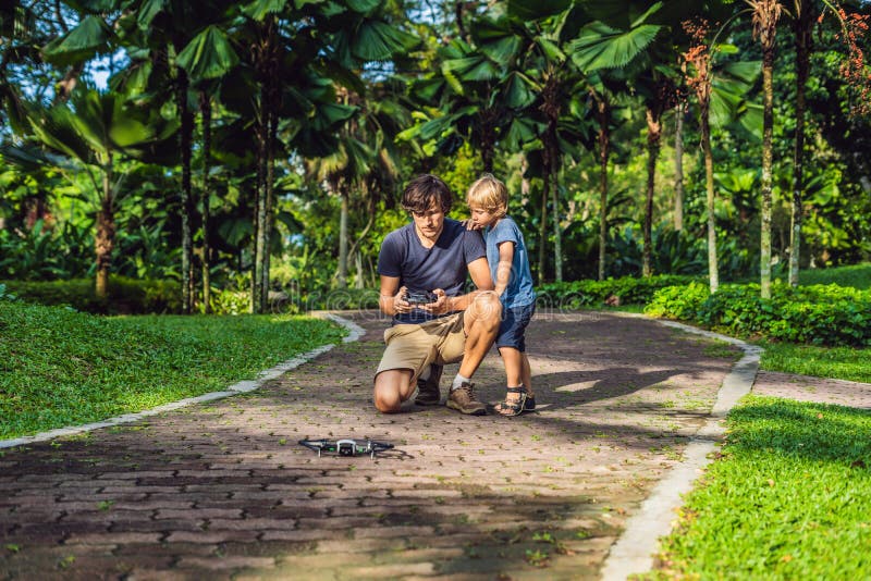 Papá e hijo que juegan con el abejón, el hombre y el muchacho jugando con el abejón que vuela en jardín soleado del otoño, el muc imagenes de archivo Papá e hijo que juegan con el abejón, el hombre y el muchacho jugando con el abejón que vuela en jardín soleado del otoño, el muc imagenes de archivo
