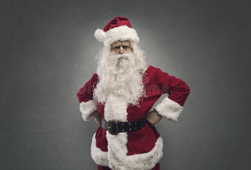 Papá Noel confiado fresco que presenta con los brazos en jarras