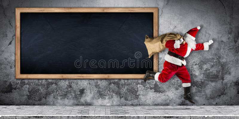 Papá Noel a toda prisa con el bolso lleno de presentes que corren el salto fotografía de archivo Papá Noel a toda prisa con el bolso lleno de presentes que corren el salto fotografía de archivo