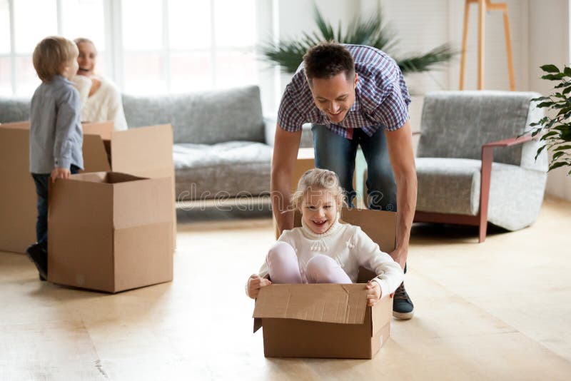 Papá que juega con el montar a caballo de la hija en caja en día móvil fotografía de archivo libre de regalías Papá que juega con el montar a caballo de la hija en caja en día móvil fotografía de archivo libre de regalías