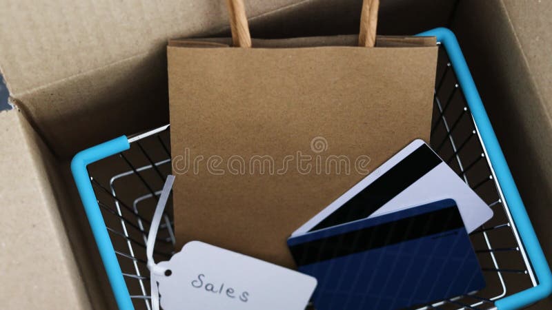 Paquete abierto con cesta de compras y bolsos con tarjetas de regalo o tarjetas de pago en el interior