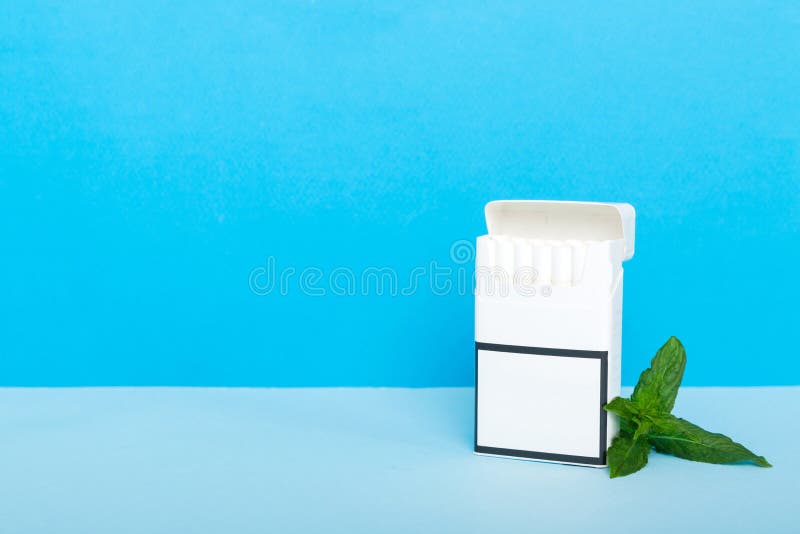 Pack of menthol cigarettes and fresh mint on colored table, Menthol cigarettes top view flat lay. Pack of menthol cigarettes and fresh mint on colored table, Menthol cigarettes top view flat lay.