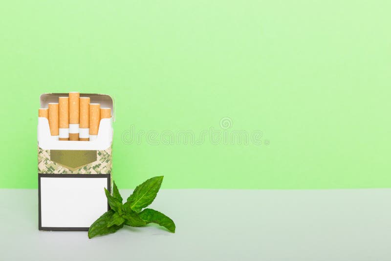 Pack of menthol cigarettes and fresh mint on colored table, Menthol cigarettes top view flat lay. Pack of menthol cigarettes and fresh mint on colored table, Menthol cigarettes top view flat lay.