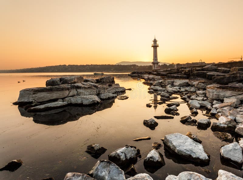 View of the lighthouse at Bains des Paquis and lake Geneva at sunrise. View of the lighthouse at Bains des Paquis and lake Geneva at sunrise.