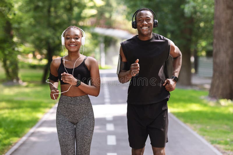 Par aktiv fritid. glad svart kille och tjej som joggar ihop i parken
