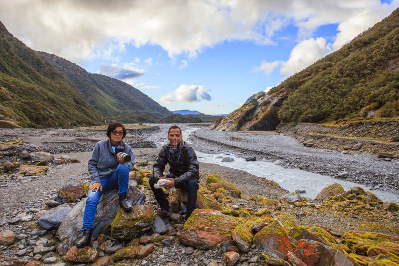 Par av den asiatiska handelsresanden som tar ett fotografi i den franz josef glaen arkivbilder Par av den asiatiska handelsresanden som tar ett fotografi i den franz josef glaen arkivbilder