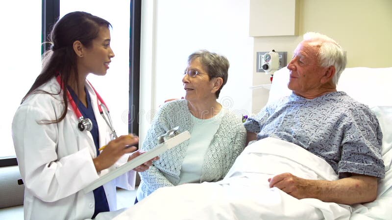 Par för doktor Talking To Senior i sjukhusrum arkivfilmer