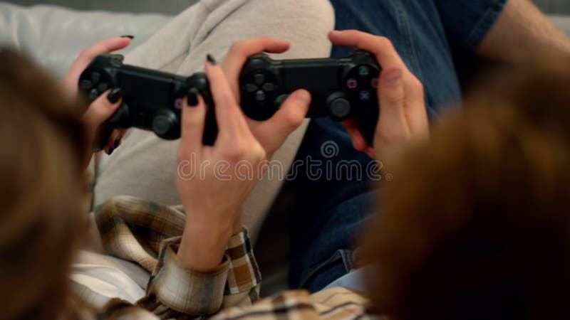 Par händer med joysticks i hemmet. människor som har kul att spela videospel