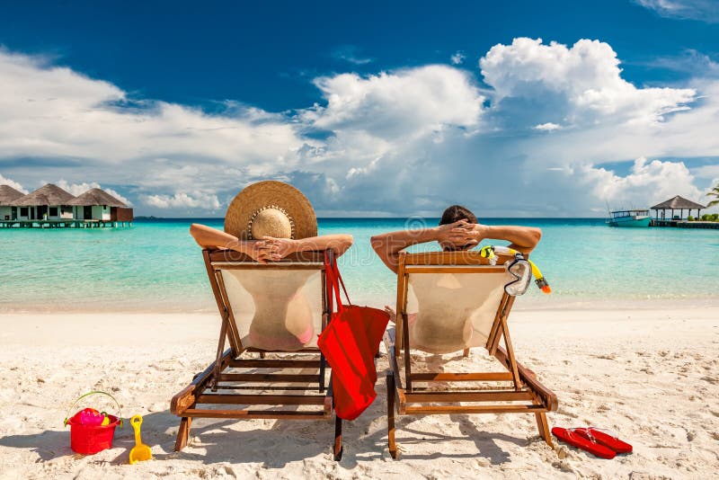 Par i dagdrivare på stranden på Maldiverna royaltyfri bild Par i dagdrivare på stranden på Maldiverna royaltyfri bild