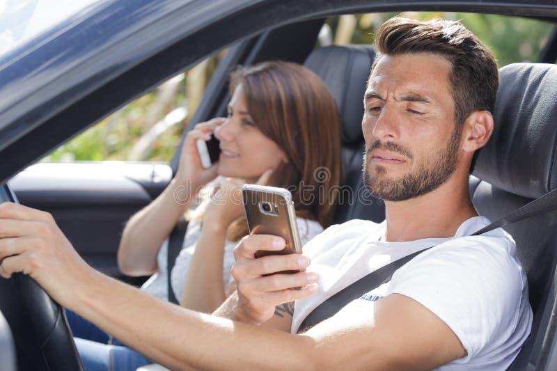 Par med mobiltelefon i bil royaltyfri foto