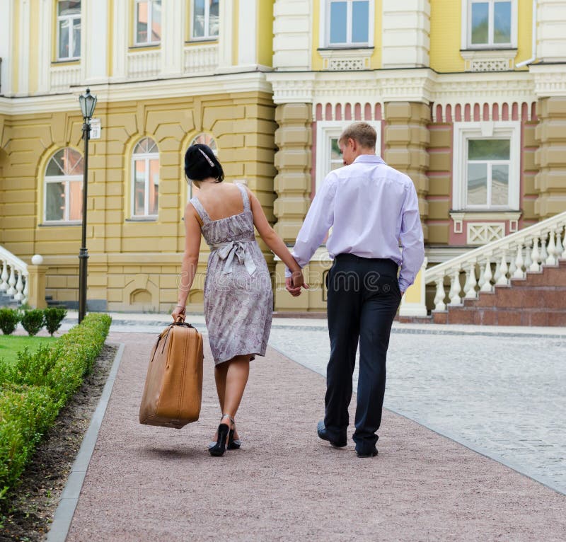 Par som går med bärande bagage för kvinna royaltyfri foto Par som går med bärande bagage för kvinna royaltyfri foto