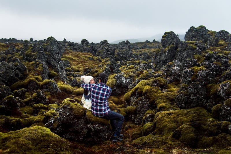 Par som kramar i ett lavafält i Island royaltyfri fotografi Par som kramar i ett lavafält i Island royaltyfri fotografi