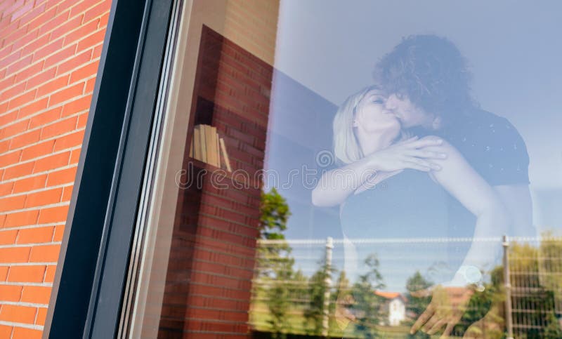 Par som kysser bak fönstret royaltyfria bilder Par som kysser bak fönstret royaltyfria bilder
