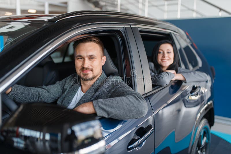Par som köper den nya bilen, avvikelse från salongen royaltyfri fotografi Par som köper den nya bilen, avvikelse från salongen royaltyfri fotografi
