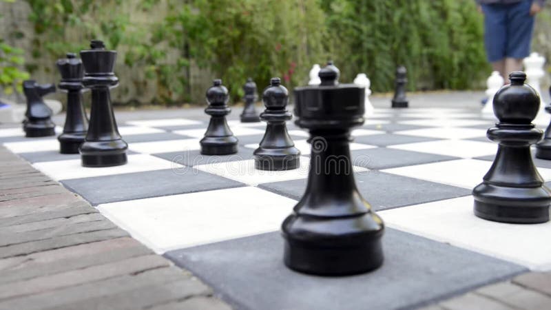 Peças grandes e tabuleiro de xadrez gigante de xadrez de rua no parque foco  seletivo