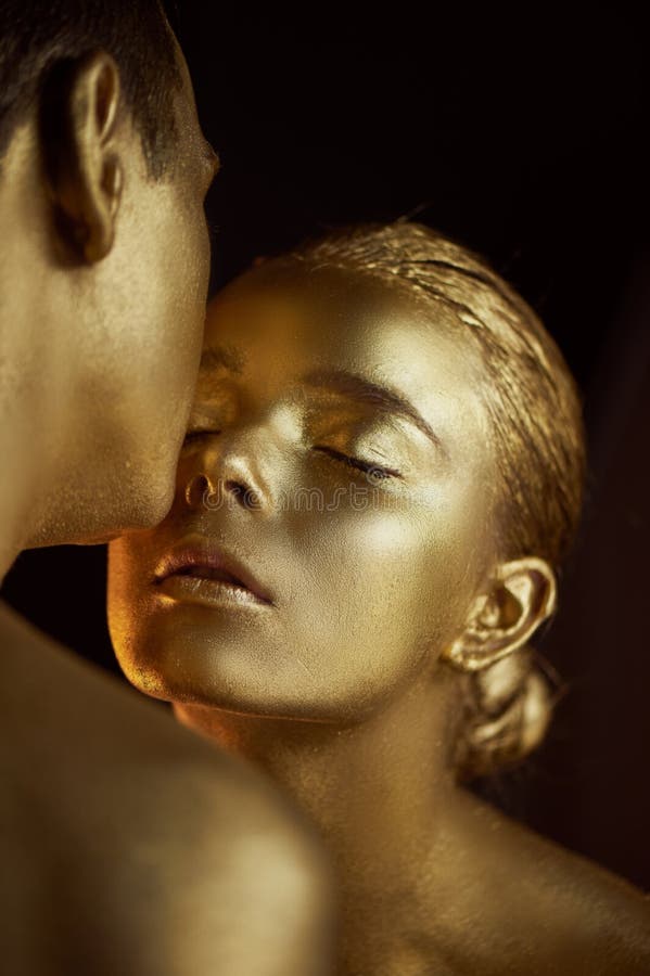 Para målat med guld- målarfärg, kyssar Frändskap unreality, enkel enhet royaltyfri fotografi Para målat med guld- målarfärg, kyssar Frändskap unreality, enkel enhet royaltyfri fotografi