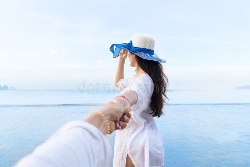 Para Na Plażowym wakacje, Pięknego młoda dziewczyna chwyta ręki Męscy ludzie Patrzeje morze zdjęcie royalty free Para Na Plażowym wakacje, Pięknego młoda dziewczyna chwyta ręki Męscy ludzie Patrzeje morze zdjęcie royalty free