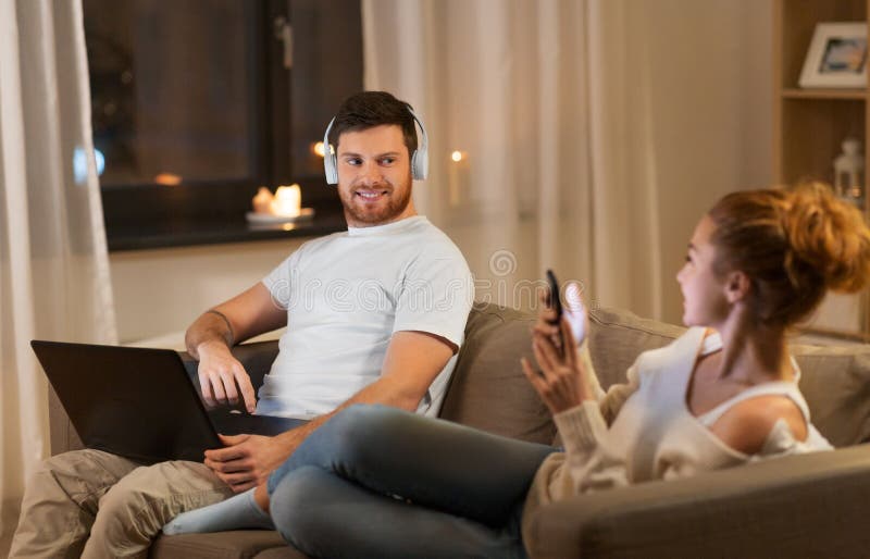 Para odpoczywa w domu z laptopem i smartphone zdjęcie stock Para odpoczywa w domu z laptopem i smartphone zdjęcie stock