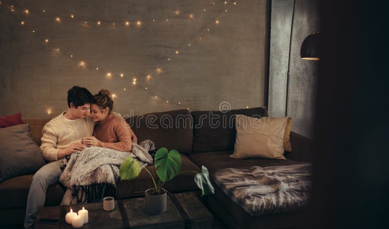 Para relaksuje na leżance w hygge domu zdjęcie stock Para relaksuje na leżance w hygge domu zdjęcie stock